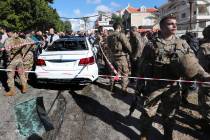 Lebanese army soldiers gather around a damaged car near the coastal town of Jadra, south Lebano ...