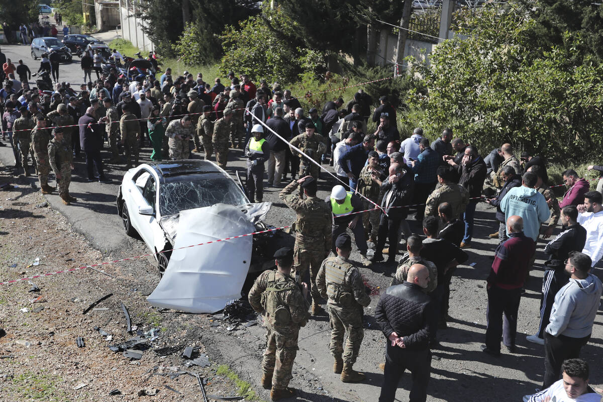 Lebanese army soldiers gather around a damaged car near the coastal town of Jadra, south Lebano ...