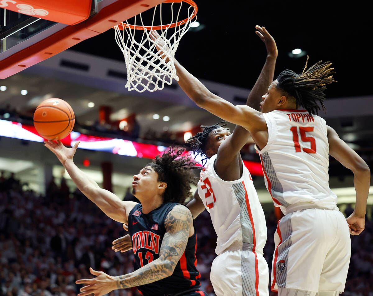 UNLV guard Brooklyn Hicks shoots and scores past the defense of New Mexico forward JT Toppin an ...