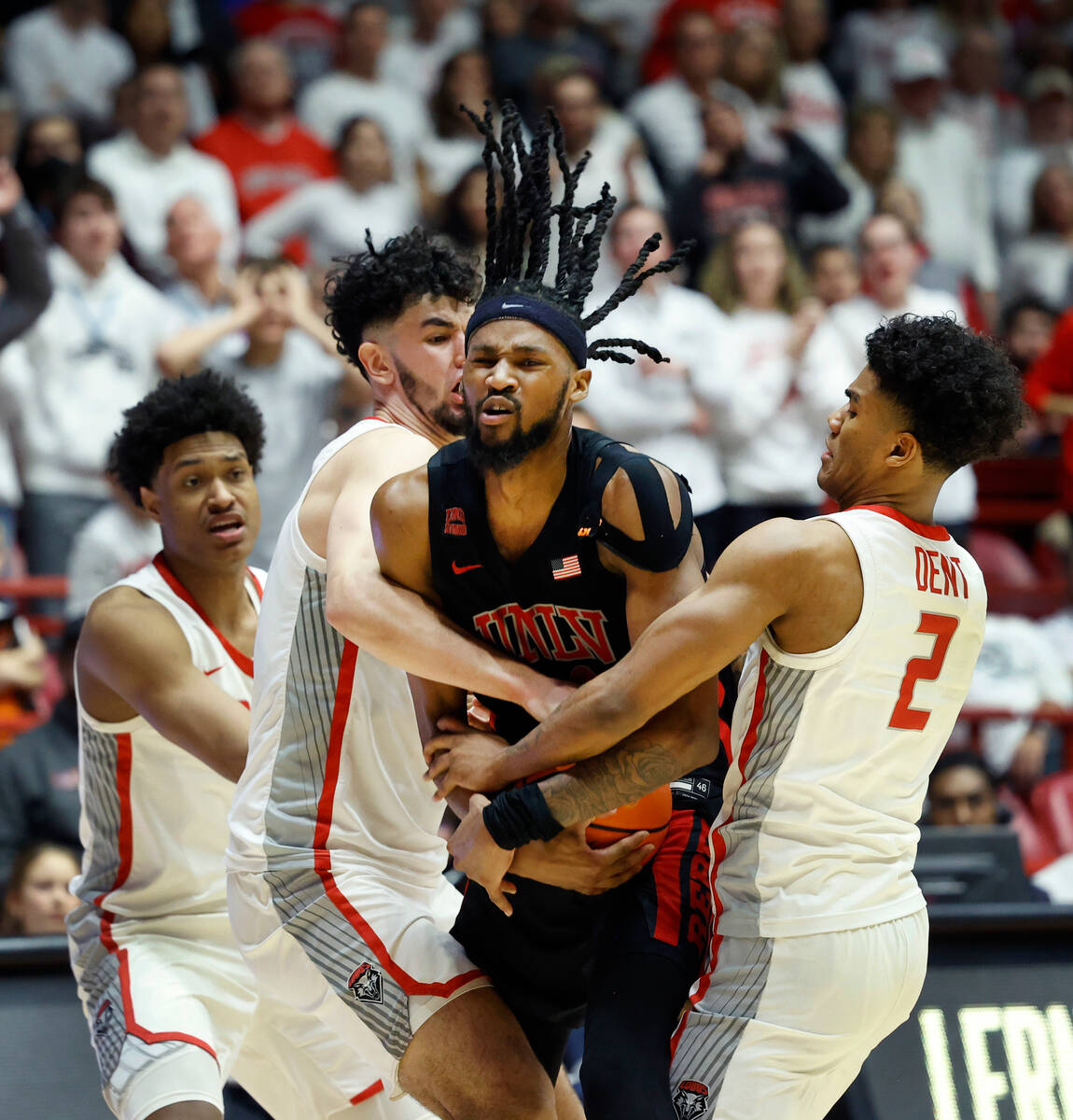 UNLV forward Kalib Boone holds onto the ball as New Mexico's Donovan Dent, right, and Mustapha ...