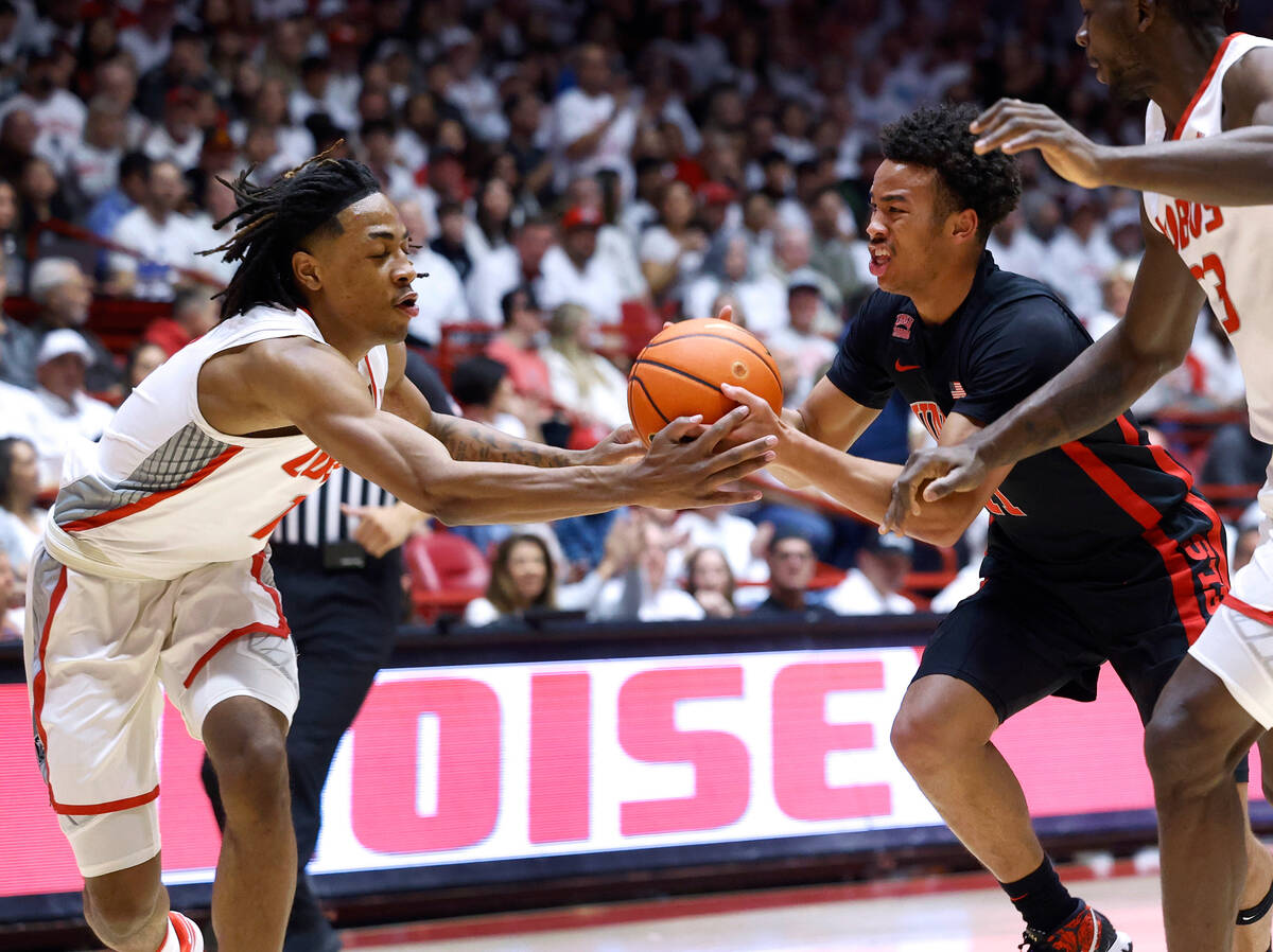 UNLV guard Dedan Thomas Jr., right, and New Mexico forward JT Toppin go after the ball during t ...