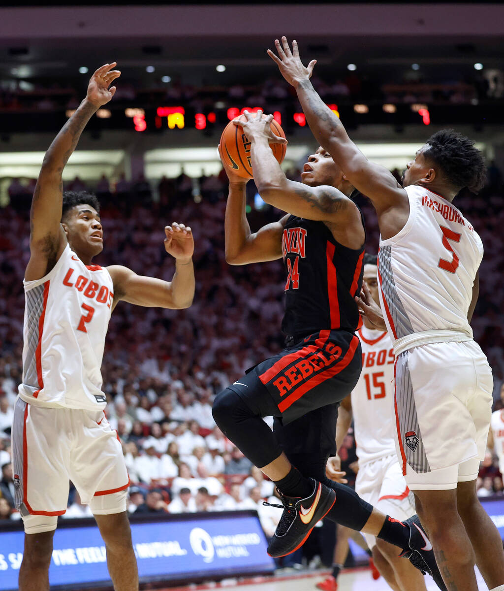 UNLV guard Jackie Johnson III splits the New Mexico defense of, from left, Donovan Dent, JT Top ...