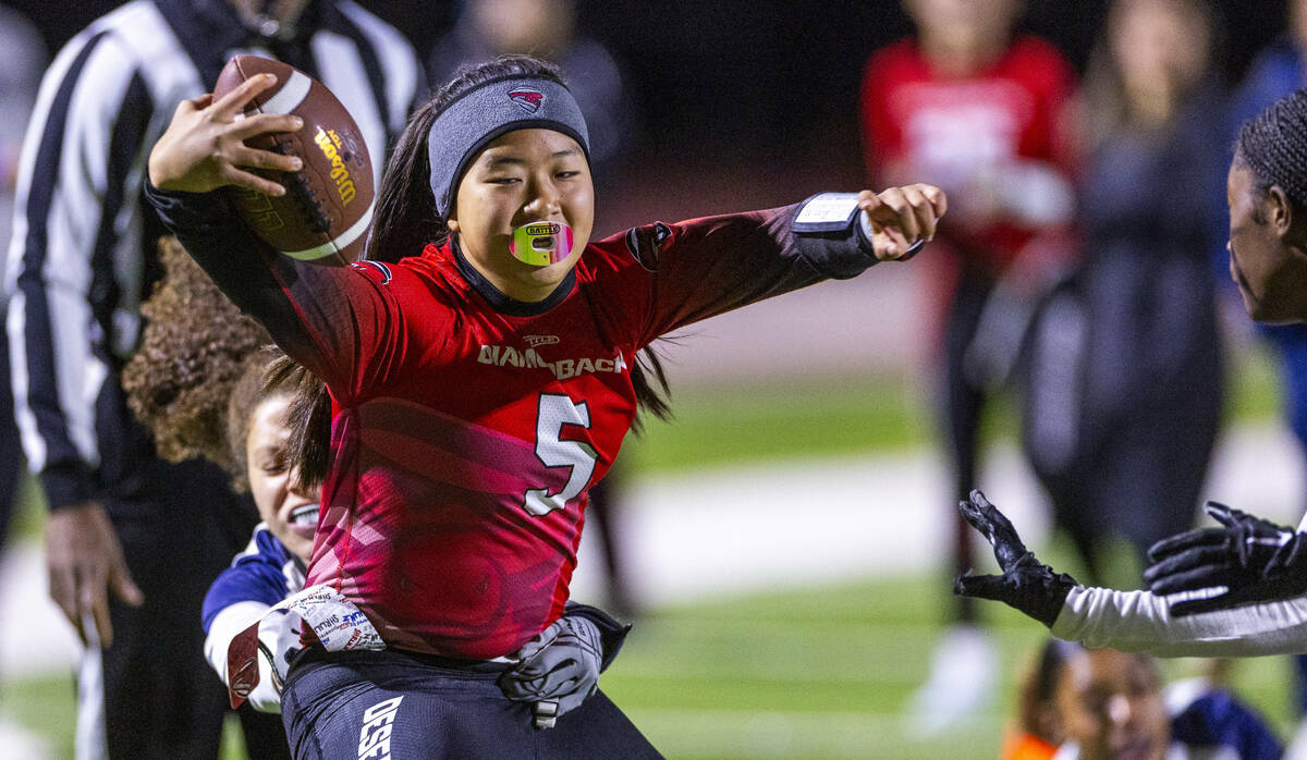 Desert Oasis quarterback Akemi Higa (5) is taken down after a long run by Shadow Ridge defender ...