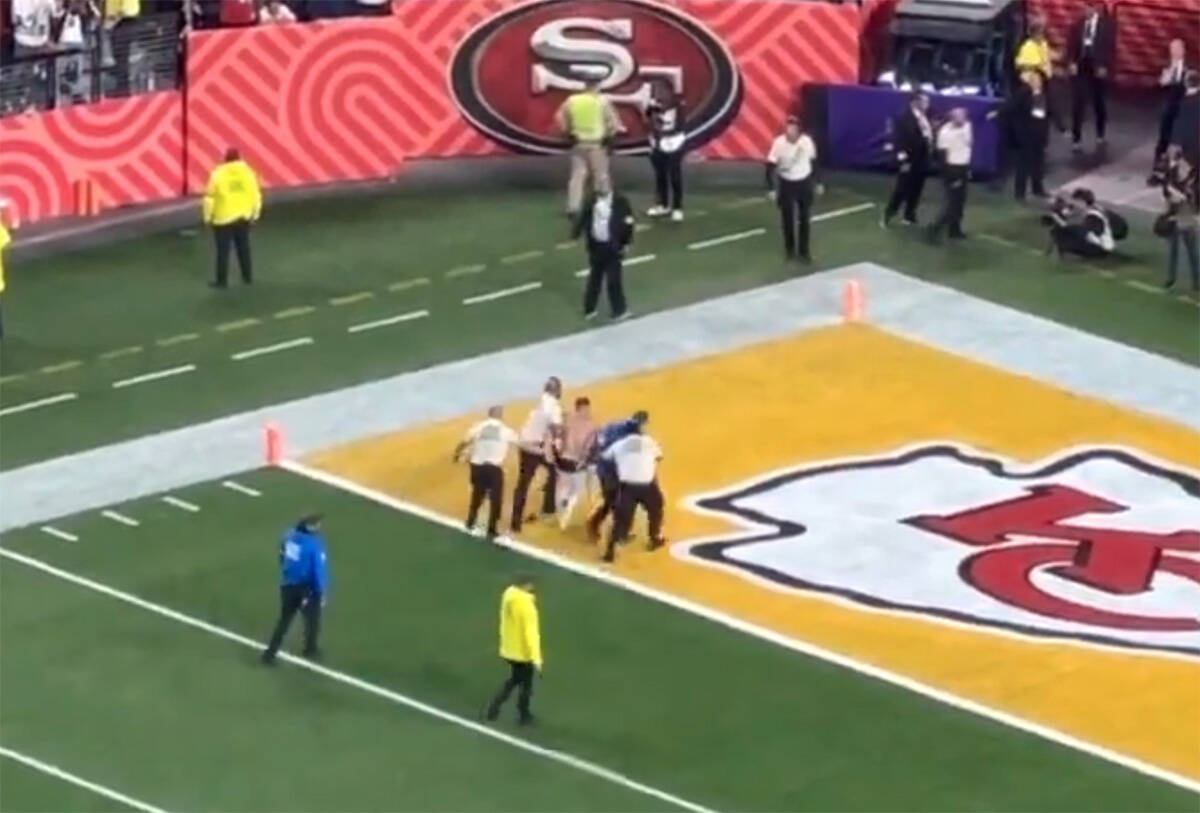 A shirtless man is escorted away by security after running on the field during Super Bowl 58 at ...