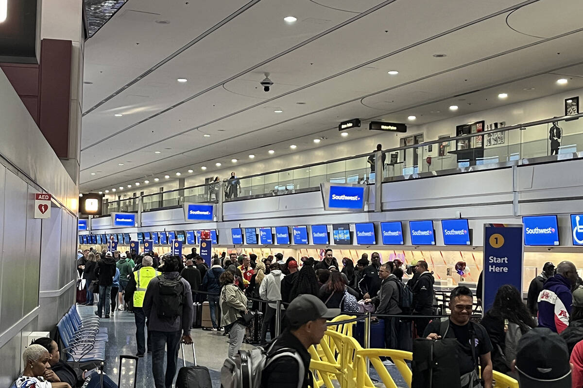 Travelers make their way through Harry Reid International Airport on Monday, Feb. 12, 2024, in ...