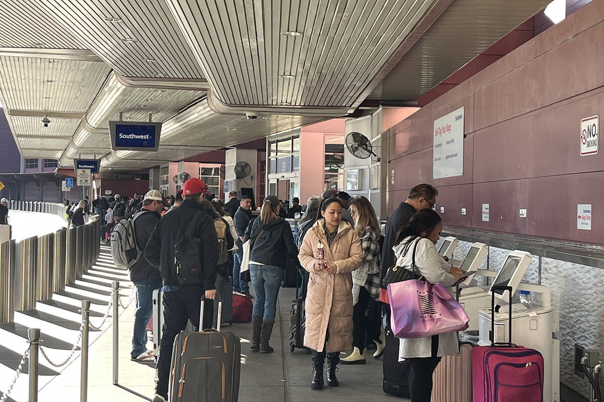 Travelers make their way through Harry Reid International Airport on Monday, Feb. 12, 2024, in ...