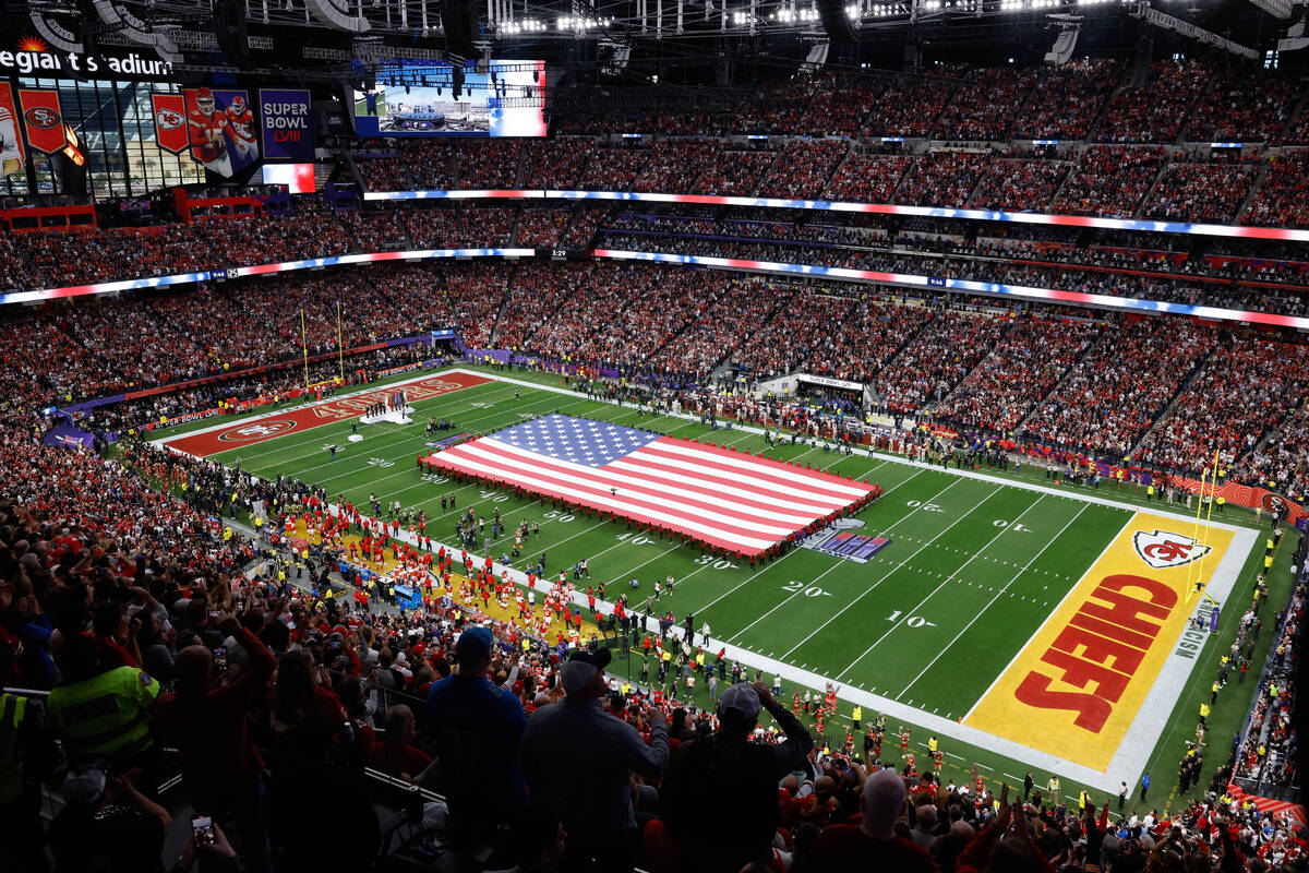 A United States flag is stretched over the field before Super Bowl 58 Sunday, Feb. 11, 2024, at ...