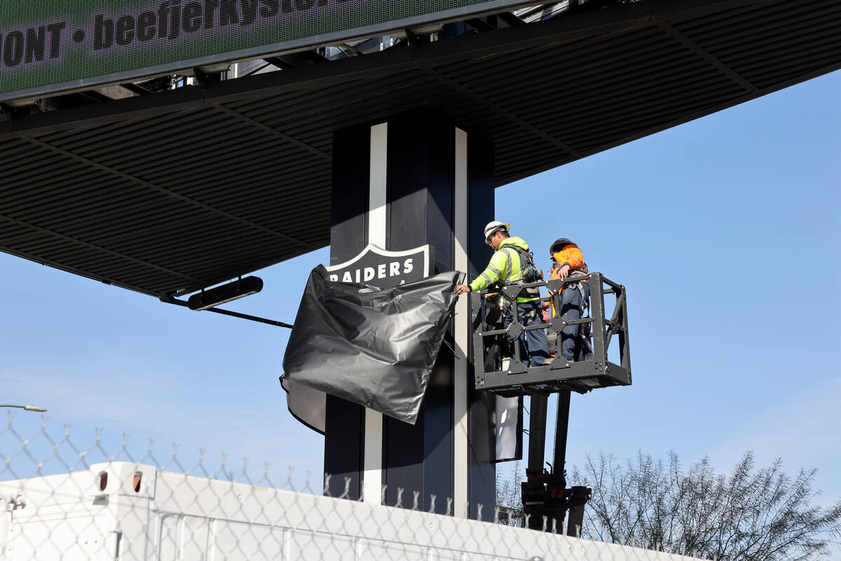 Crews remove a covering on a Raiders shield from the 2024 Super Bowl at Allegiant Stadium in La ...