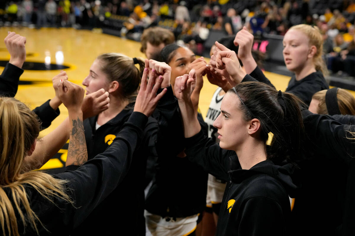 Iowa players, including guard Caitlin Clark, right foreground, huddle before the team's NCAA co ...
