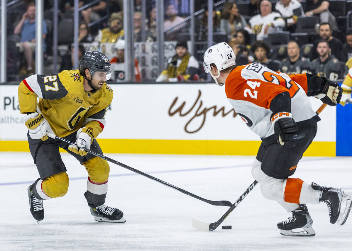 Golden Knights defenseman Shea Theodore (27) looks to score past Philadelphia Flyers defenseman ...