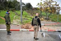 Israeli security forces examine the site hit by a rocket fired from Lebanon, in Safed, northern ...