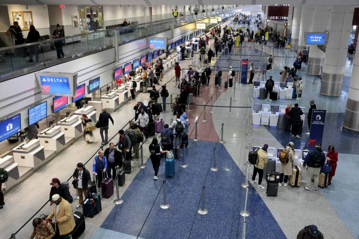Travelers check their bags a Harry Reid International Airport on Monday, Feb. 12, 2024, a day a ...