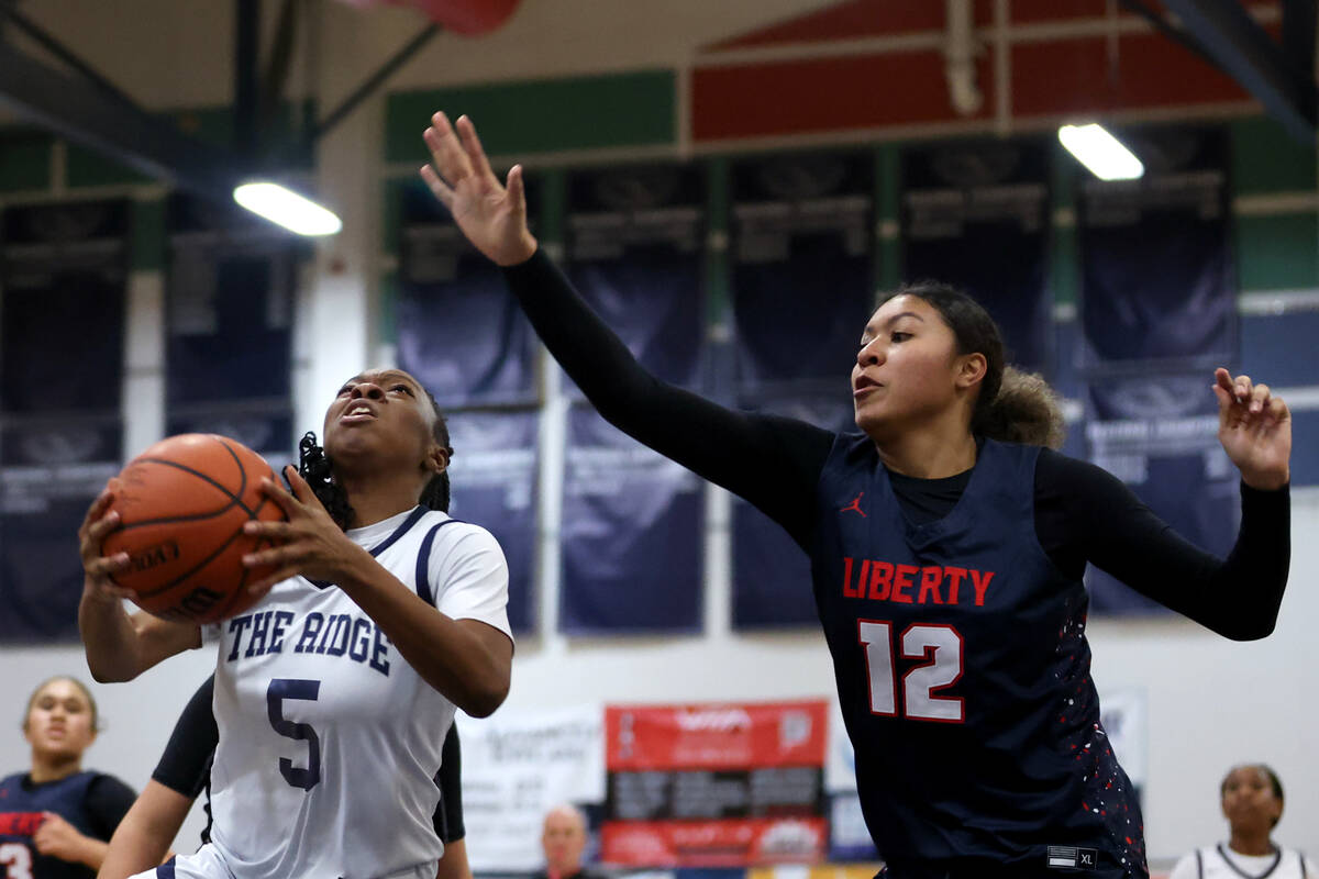 Shadow Ridge guard Zh'mya Martin (5) shoots against Liberty's Daisha Peavy (12) during the firs ...