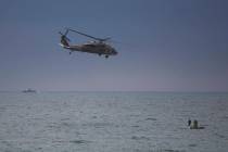 Israeli helicopter flies over Palestinian fishermen near Khan Younis, Gaza Strip, Thursday, Feb ...