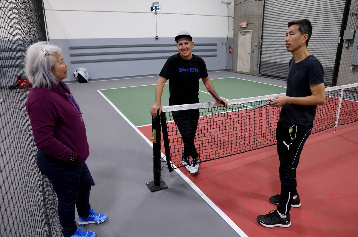 Phil Wexler, 58, of Miami, center, visits with Siu-Imm Tay, left, and Leslie Lau, 51, both of C ...