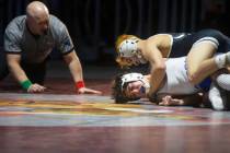 The referee looks in as SLAM Nevada’s Manuel Saldate works to pin Carson High School&#x2 ...