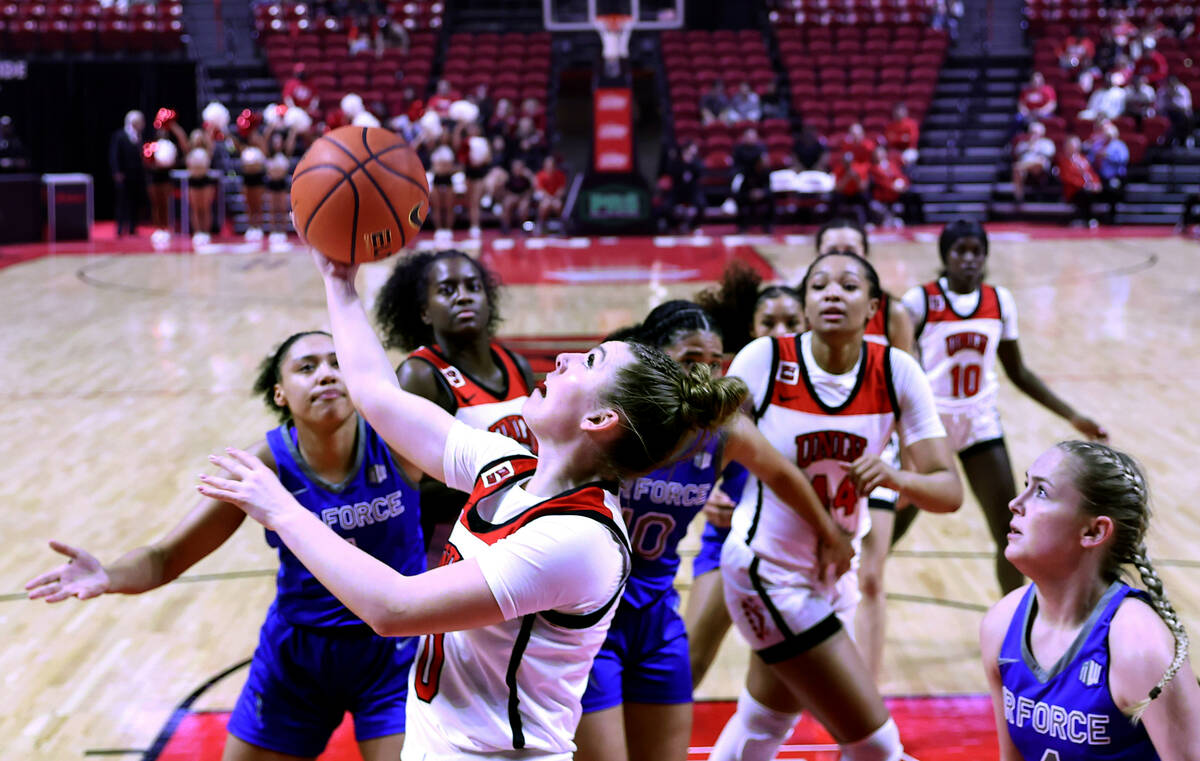 UNLV Lady Rebels guard Ashley Scoggin (0) gets off a backwards shot underneath the basket as Ai ...