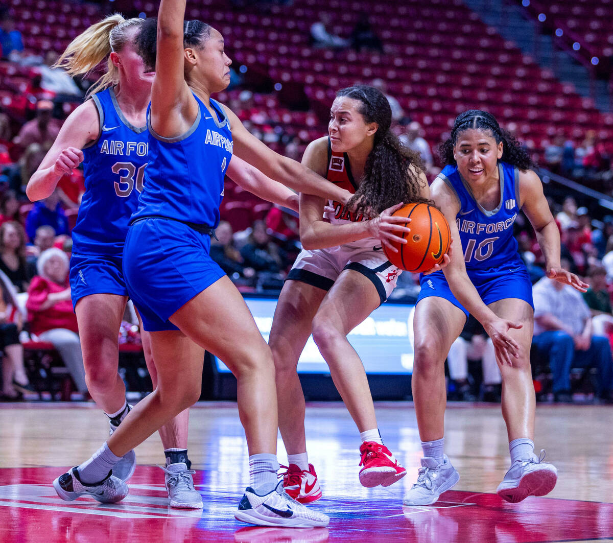 UNLV Lady Rebels guard Kiara Jackson (3) controls the ball amongst Air Force Falcons guard Alex ...