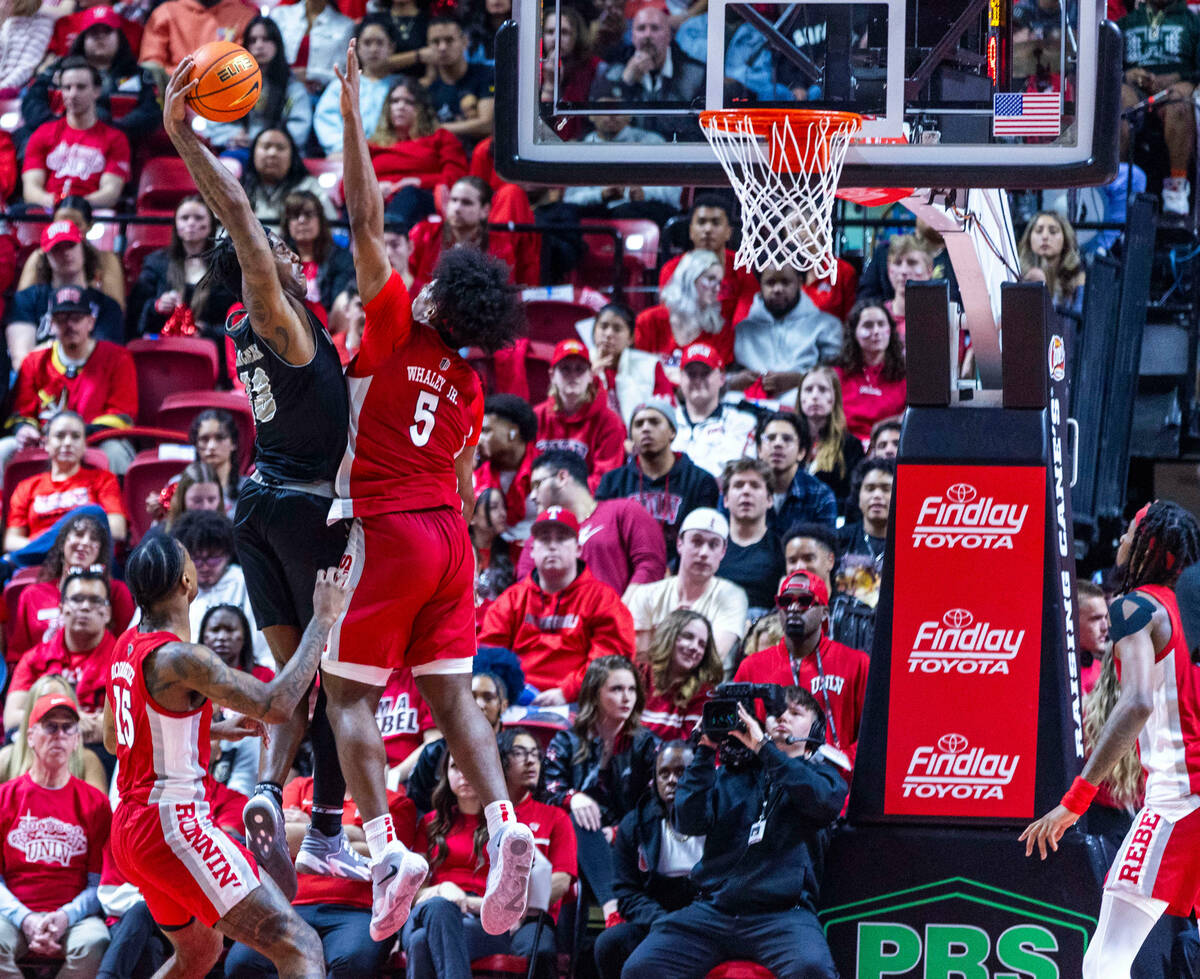 UNR guard Kenan Blackshear (13) posts up for a shot against UNLV Rebels forward Rob Whaley Jr. ...