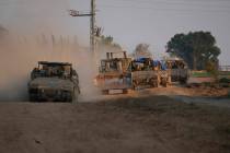 A column of armored Israeli army vehicles drives in southern Israel near the Gaza border, Frida ...
