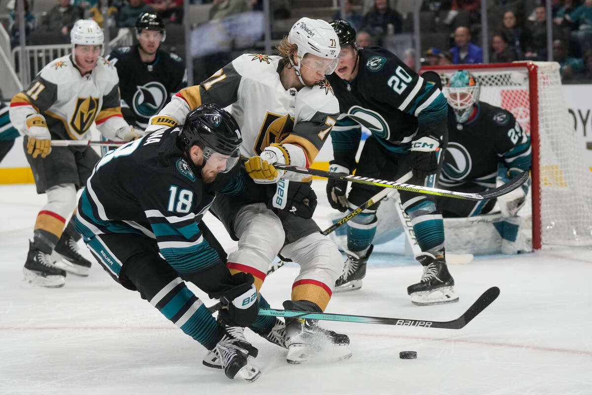 Vegas Golden Knights center William Karlsson, middle, looks toward the puck between San Jose Sh ...