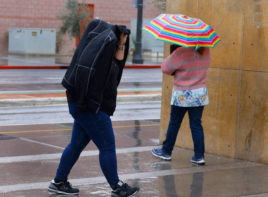 Pedestrians walk along Third Street during a rainy morning Tuesday, Feb. 20, 2024, in Las Vegas ...