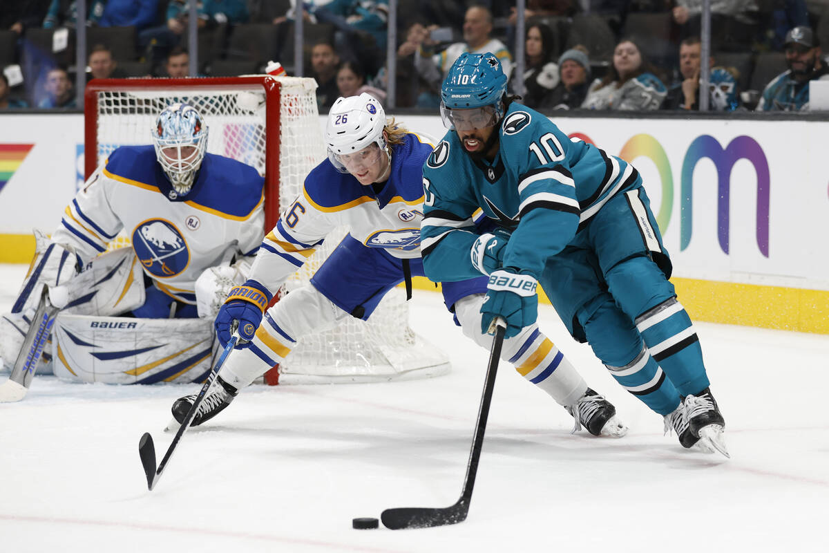 Buffalo Sabres defenseman Rasmus Dahlin (26) compete for possession of the puck against the San ...