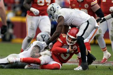 Kansas City Chiefs quarterback Patrick Mahomes (15) is stopped by Las Vegas Raiders defensive e ...