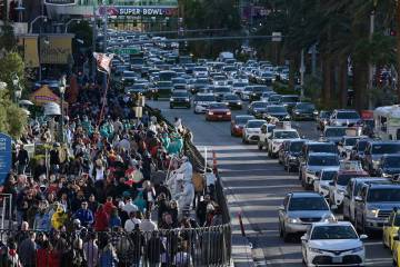 Crowds of people and backed up traffic on the Strip are seen the day before Super Bowl LVIII Sa ...