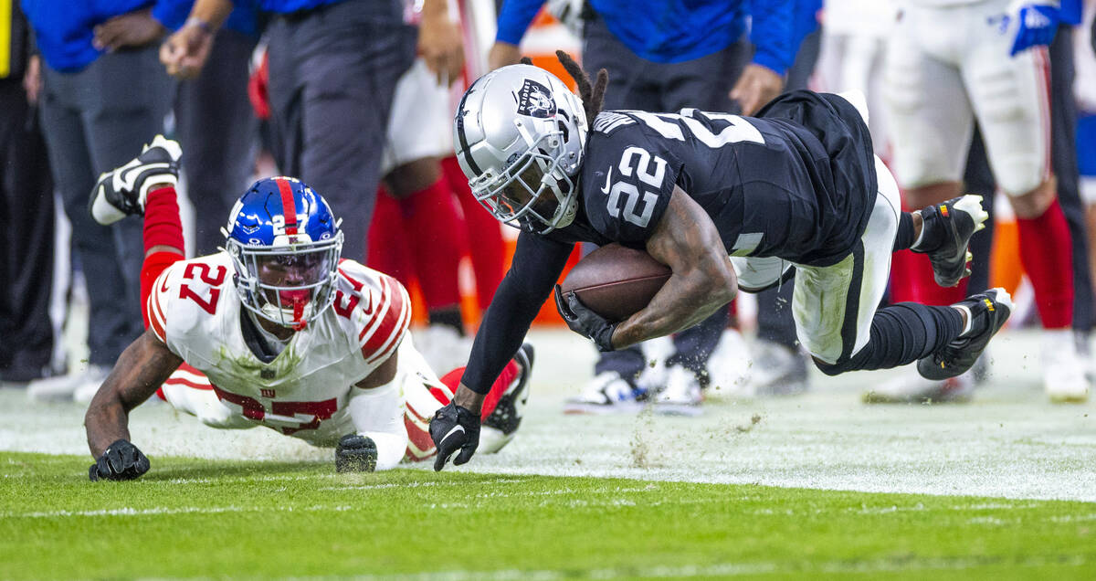 Vegas Raiders running back Ameer Abdullah (22) touches a finger on the turf after a hit from Ne ...