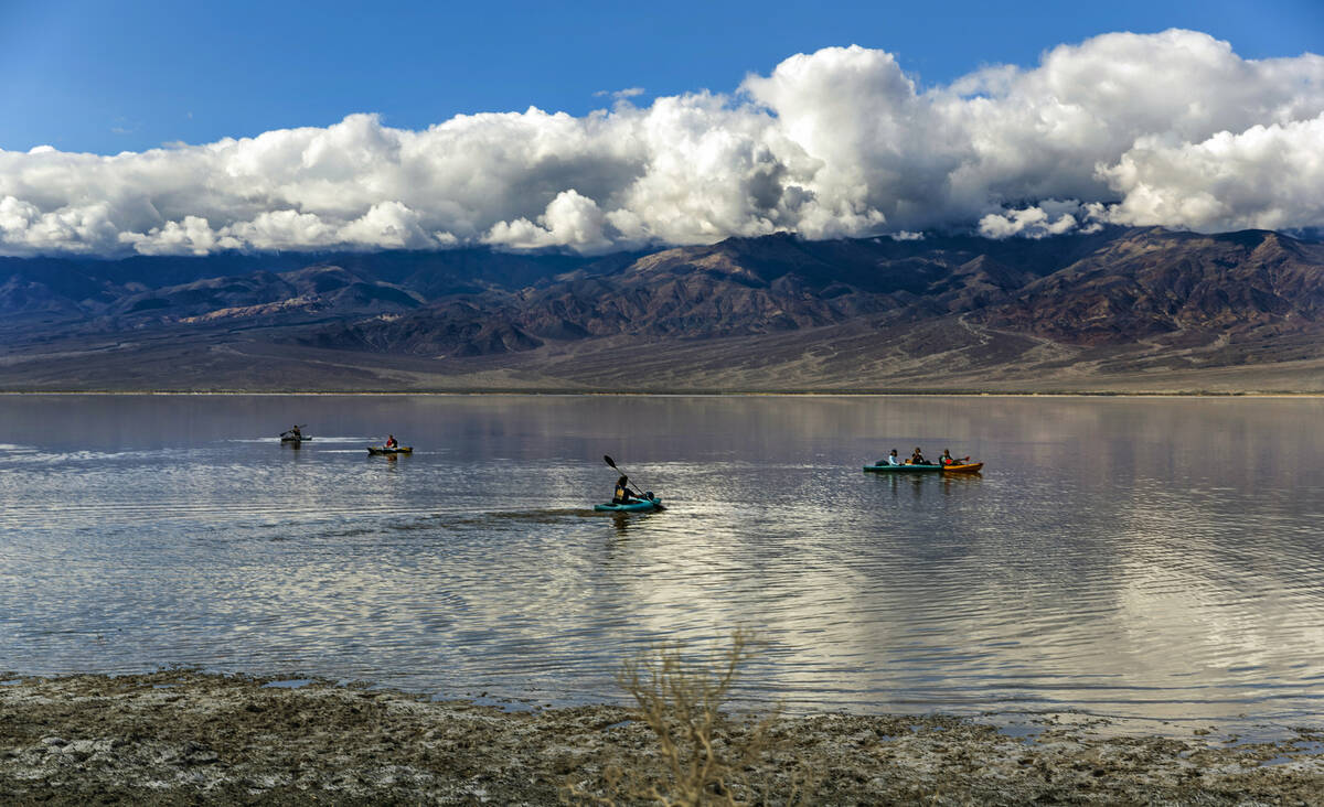 People paddle on kayaks on the temporary Lake Manly at Badwater Basin in Death Valley National ...