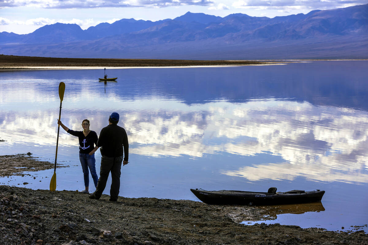 People paddle on kayaks on the temporary Lake Manly at Badwater Basin in Death Valley National ...