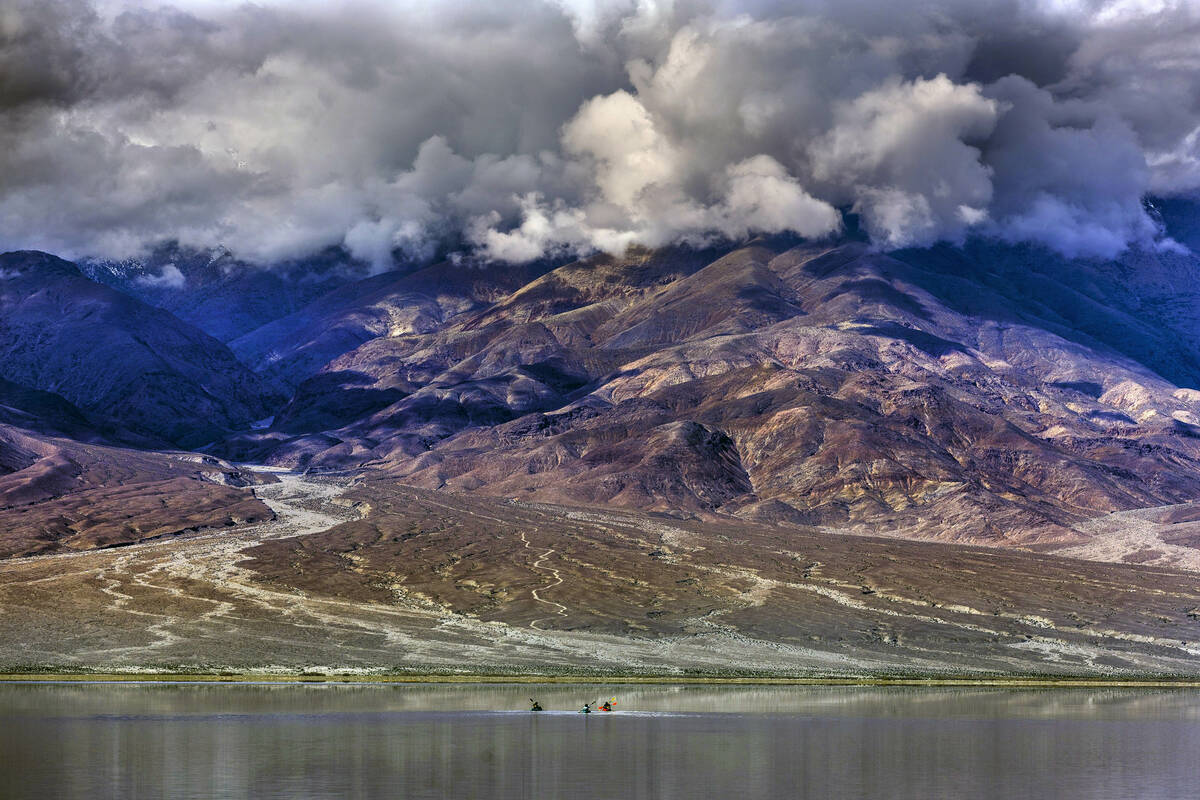 People paddle on kayaks on the temporary Lake Manly at Badwater Basin in Death Valley National ...