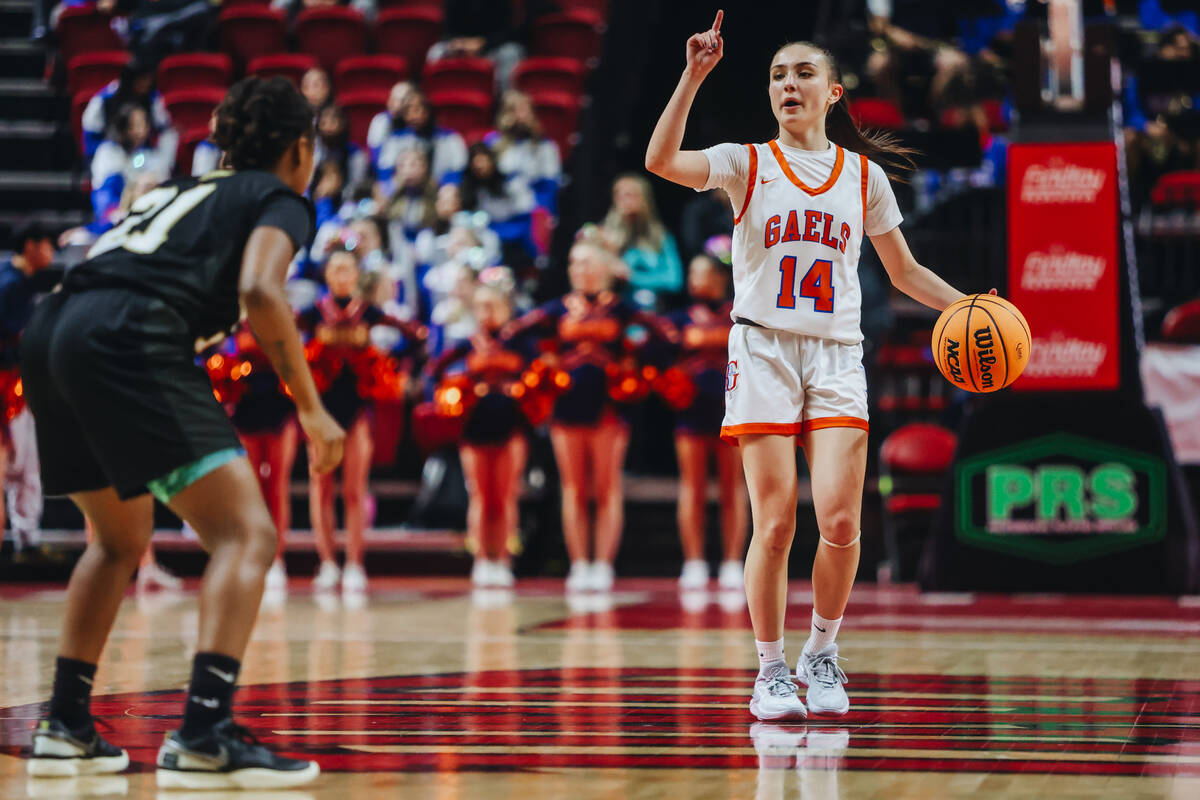 Bishop Gorman point guard Kenzee Holton (14) signals to a teammate as she dribbles the ball dow ...
