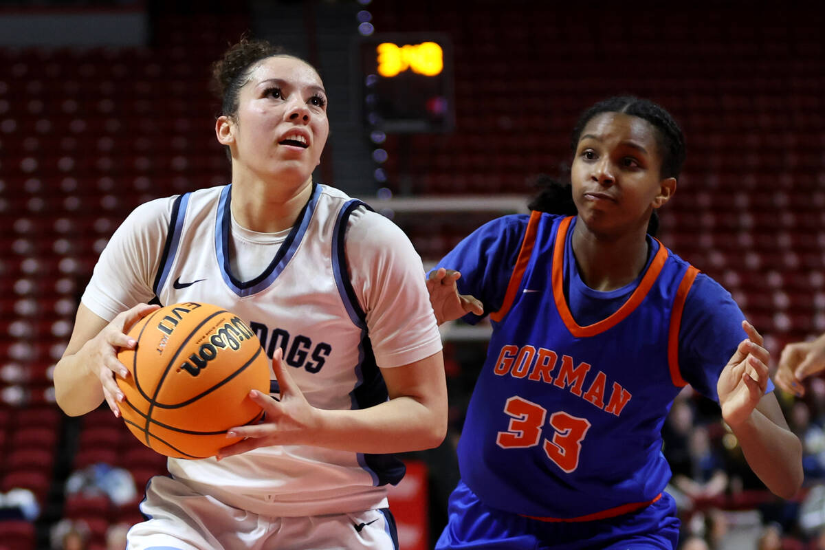 Centennial's Jada Price (15) drives toward the hoop against Bishop Gorman's Neeyah Webster (33) ...