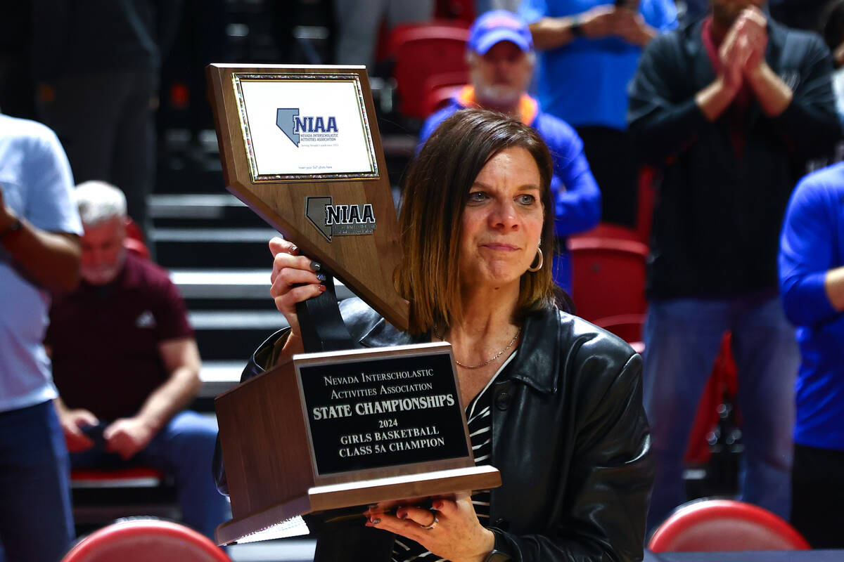 Bishop Gorman head coach Sheryl Krmpotich holds up her team’s trophy after they defeated ...