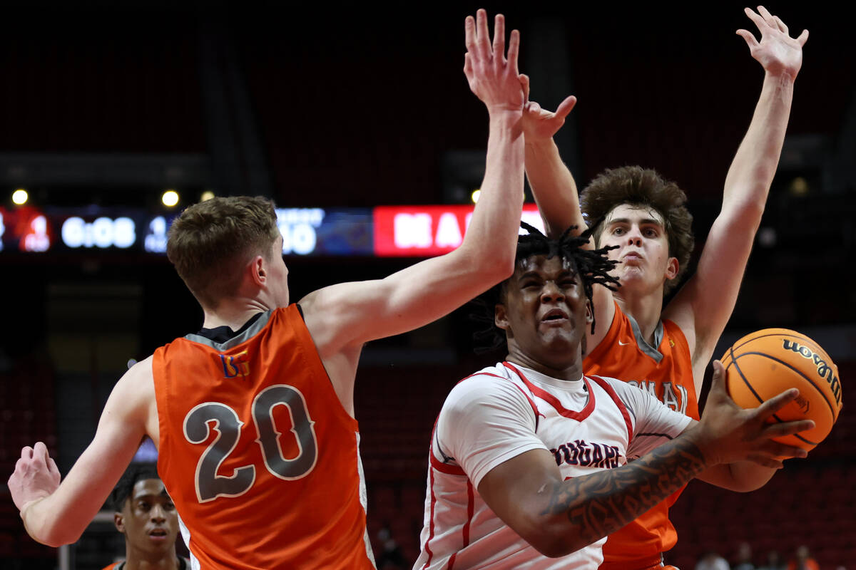 Coronado's Tee Bartlett (13) drives toward the hoop between Bishop Gorman's Ilan Nikolov (20) a ...