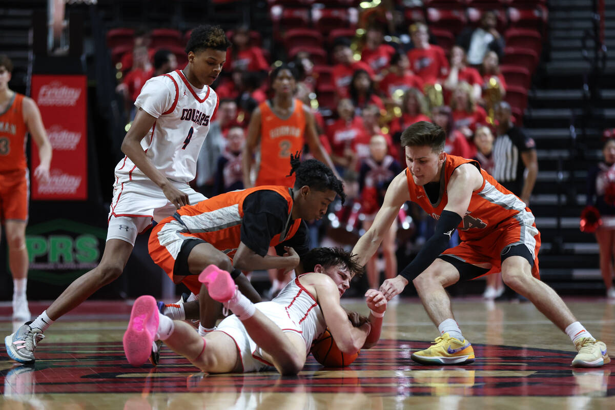 Coronado's JJ Buchanan (10) fights for the ball with Bishop Gorman's Jett Washington, center le ...