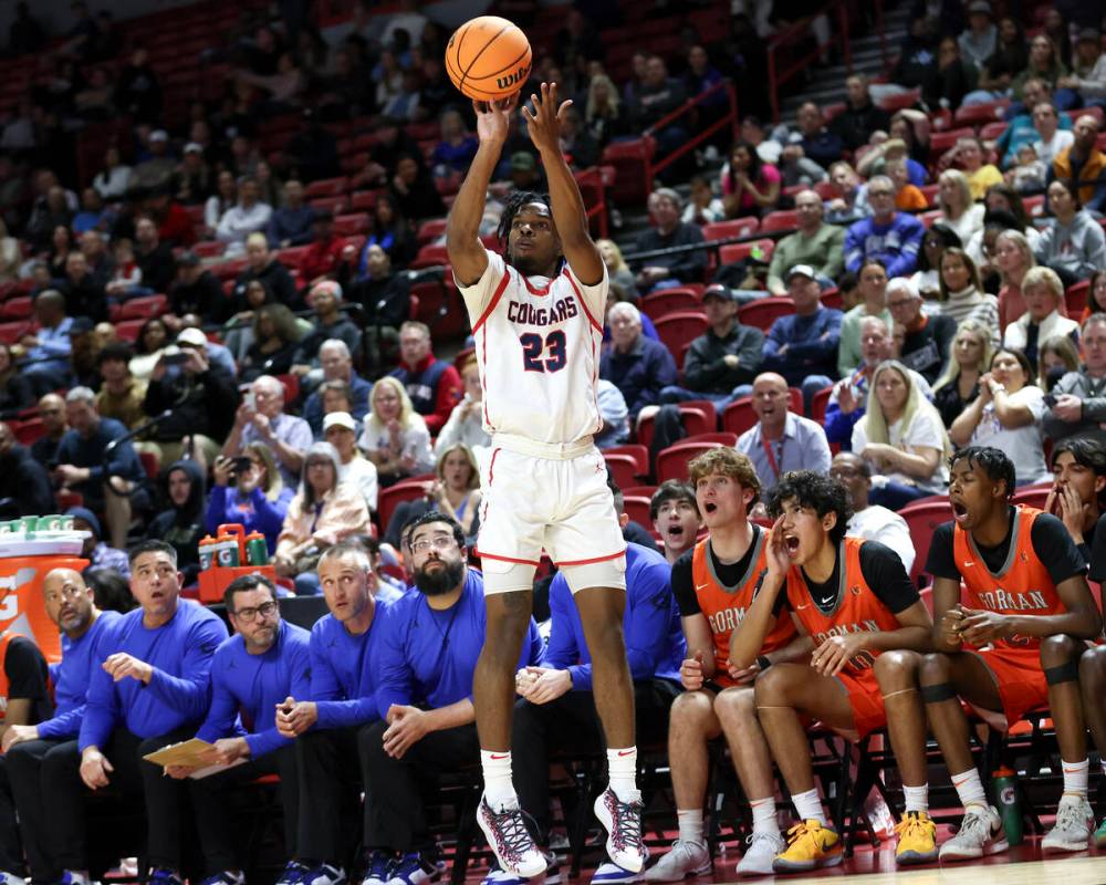 Coronado's Josiah Cunningham (23) shoots a three-pointer while the Bishop Gorman bench heckles ...