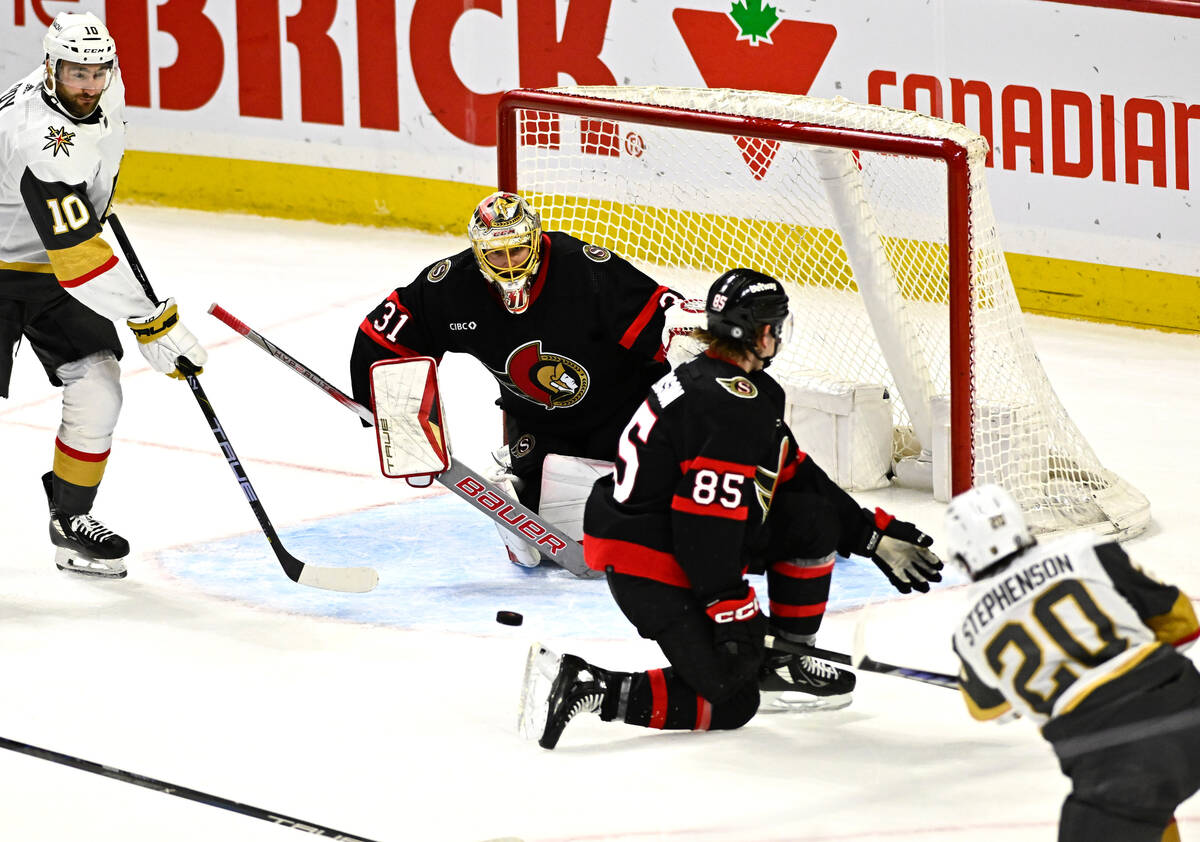 Ottawa Senators goaltender Anton Forsberg (31) and defenseman Jake Sanderson (85) are unable to ...