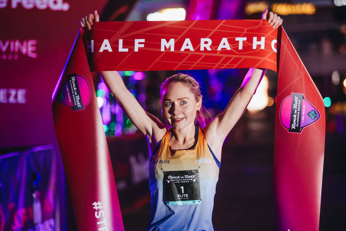 Alice Wright raises the half marathon finishing line ribbon after coming in first for the women ...