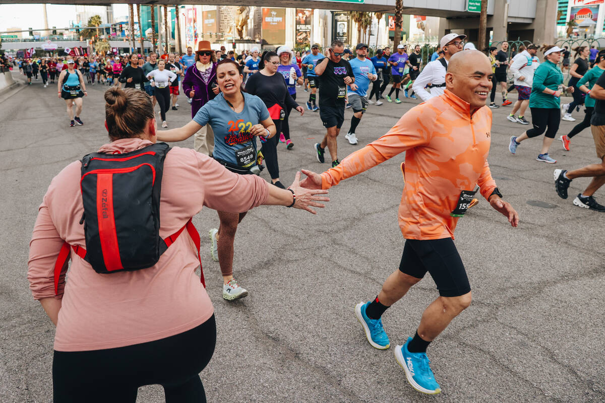 A supporter high-fives runners during the Rock ’n’ Roll Running Series on Las Veg ...