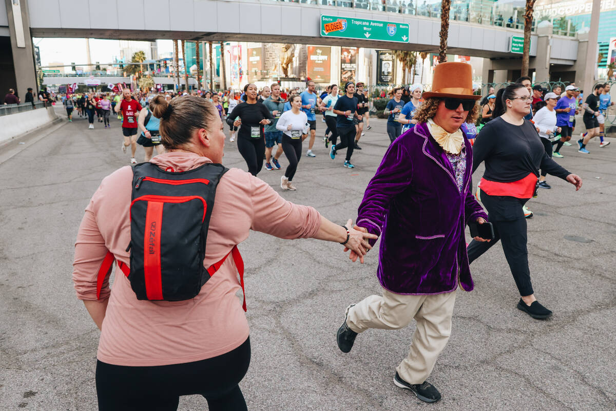 A runner dressed like Willy Wonka high fives a supporter during the Rock ’n’ Roll ...