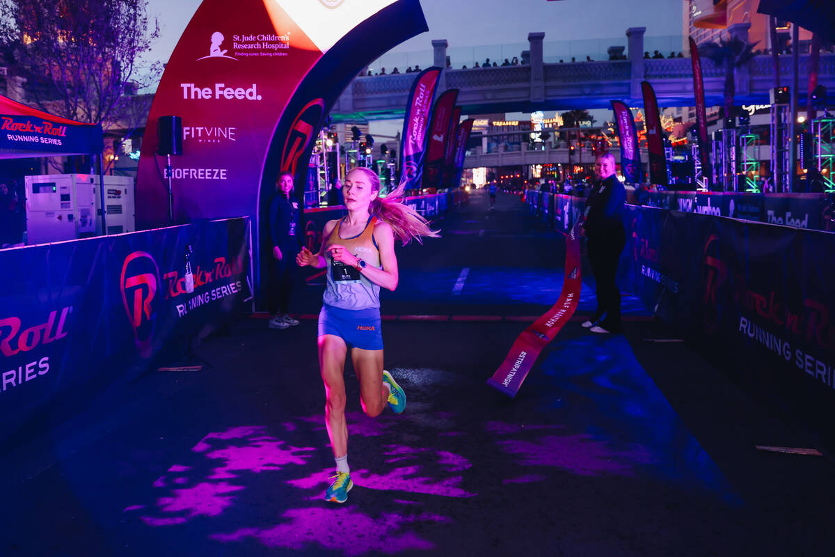 Alice Wright runs past the finish line after coming in first in the women’s half maratho ...