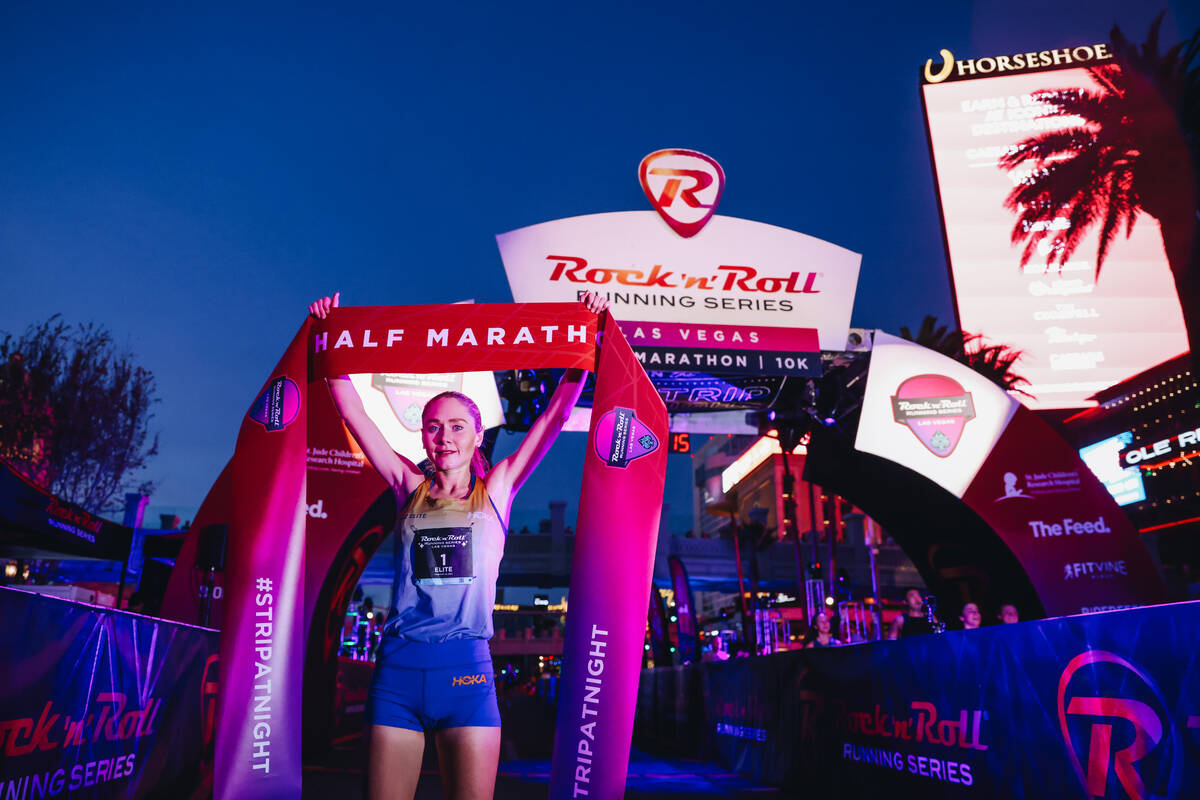 Alice Wright raises the half marathon finishing line ribbon after coming in first for the women ...