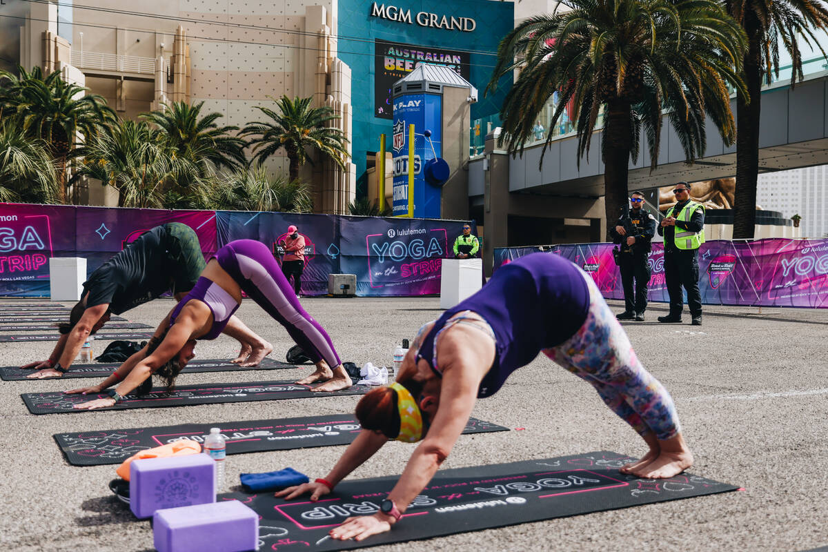 Police watch as people gather on the Strip to do yoga while it is shut down for the Rock &#x201 ...