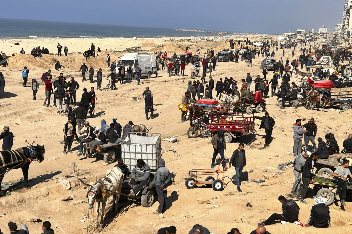 Palestinians wait for humanitarian aid on a beachfront in Gaza City, Gaza Strip, Sunday, Feb. 2 ...