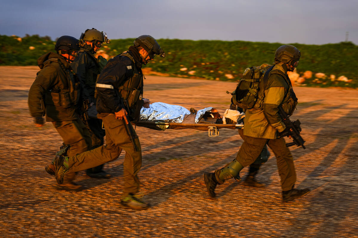 Israeli soldiers run as they carry a stretcher towards a military helicopter during an exercise ...