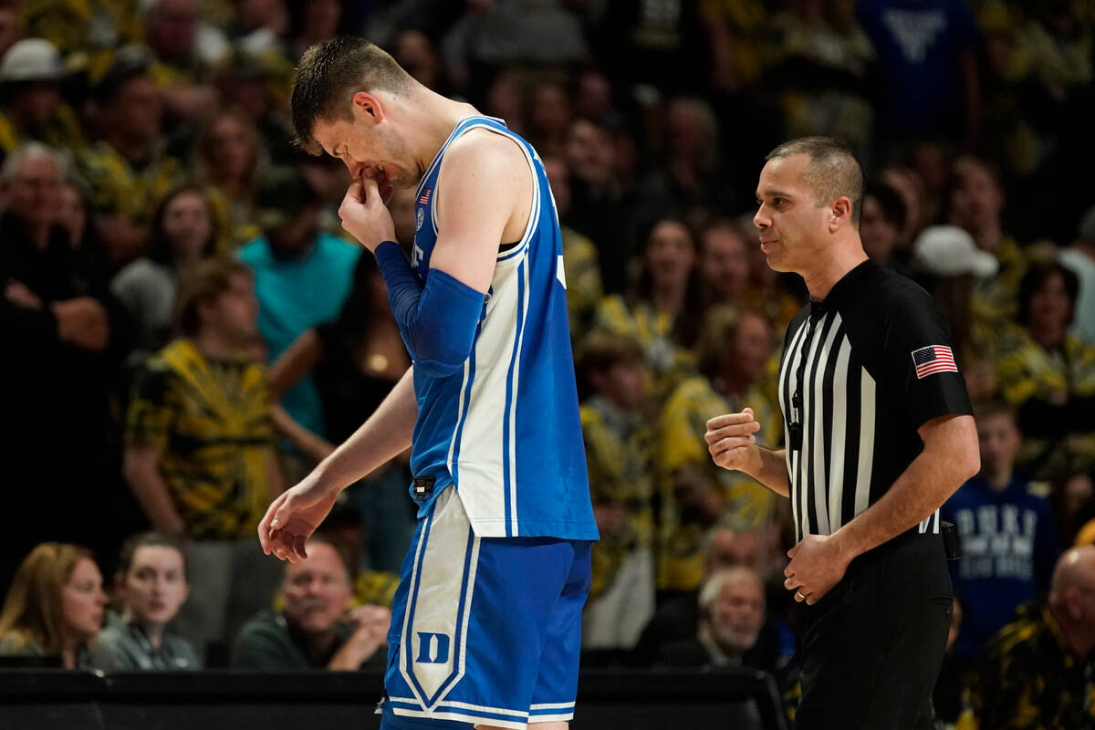 Duke's Kyle Filipowski holds his bloodied nose as he leaves the floor during the second half of ...