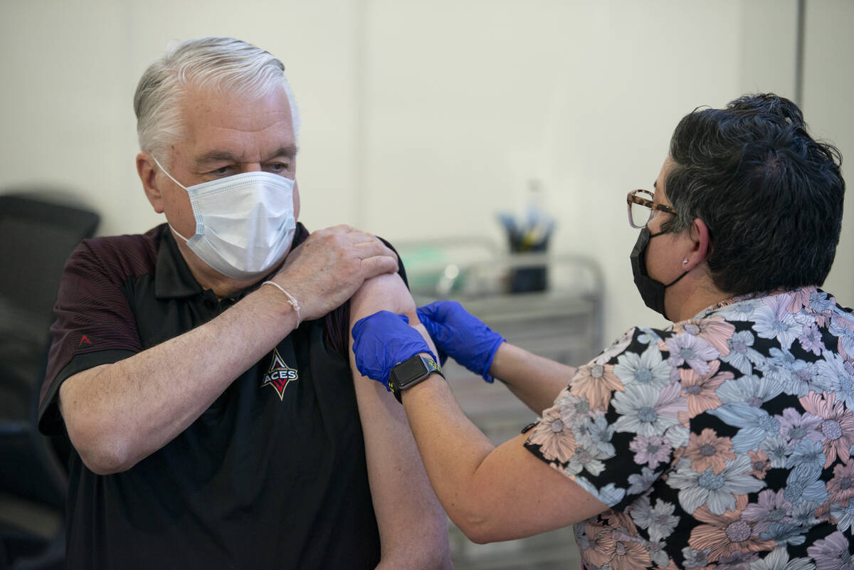 Nevada Governor Steve Sisolak gets a bandage from nurse KJ Dionisio after receiving his second ...